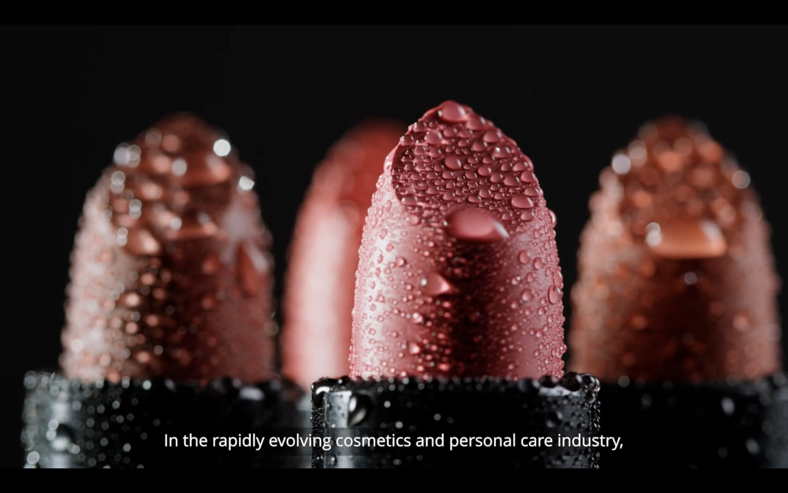 Close-up of three lipsticks with water droplets against a black background. The focus is on the middle lipstick, symbolizing the future of beauty. The text at the bottom reads, 